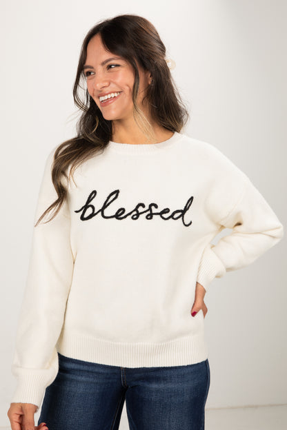 Woman wearing a white sweater with &