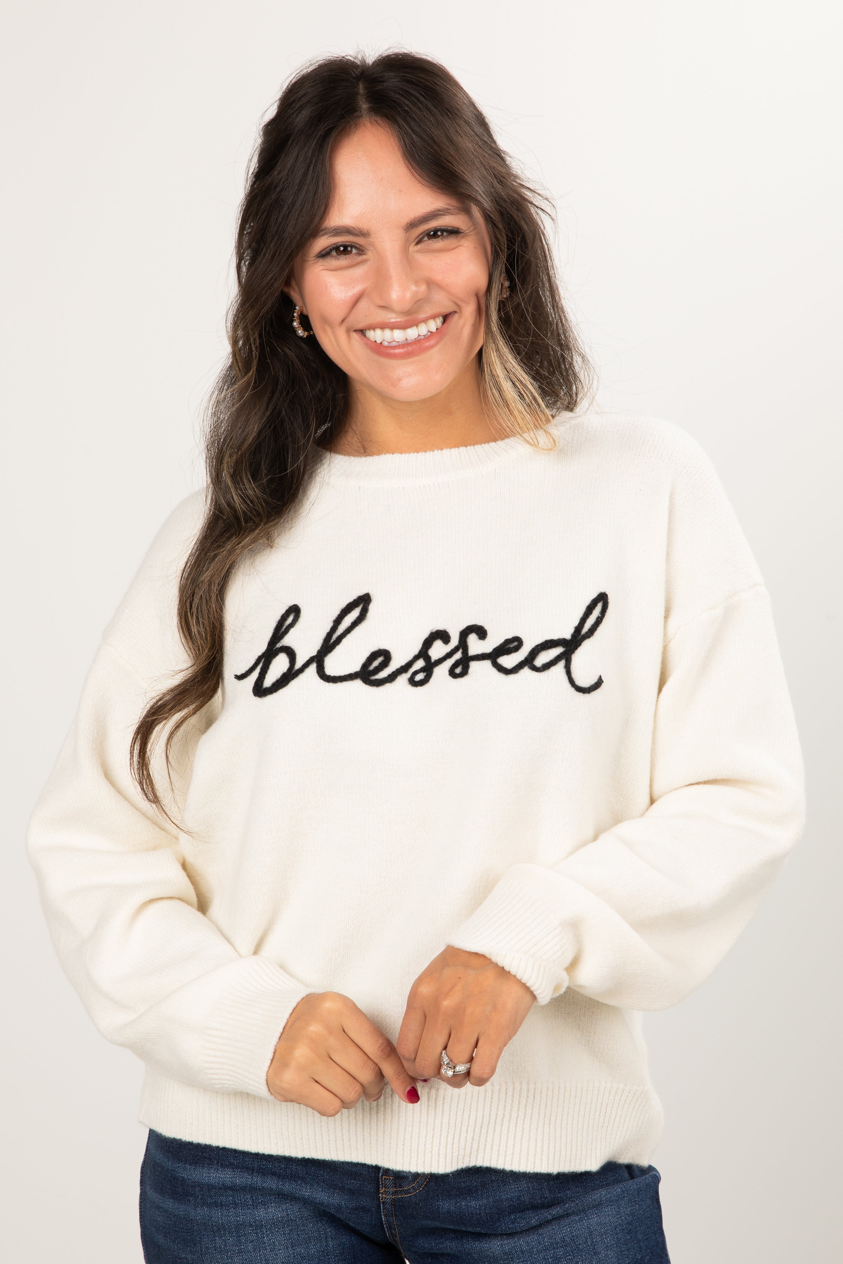 Woman wearing a white sweater with &