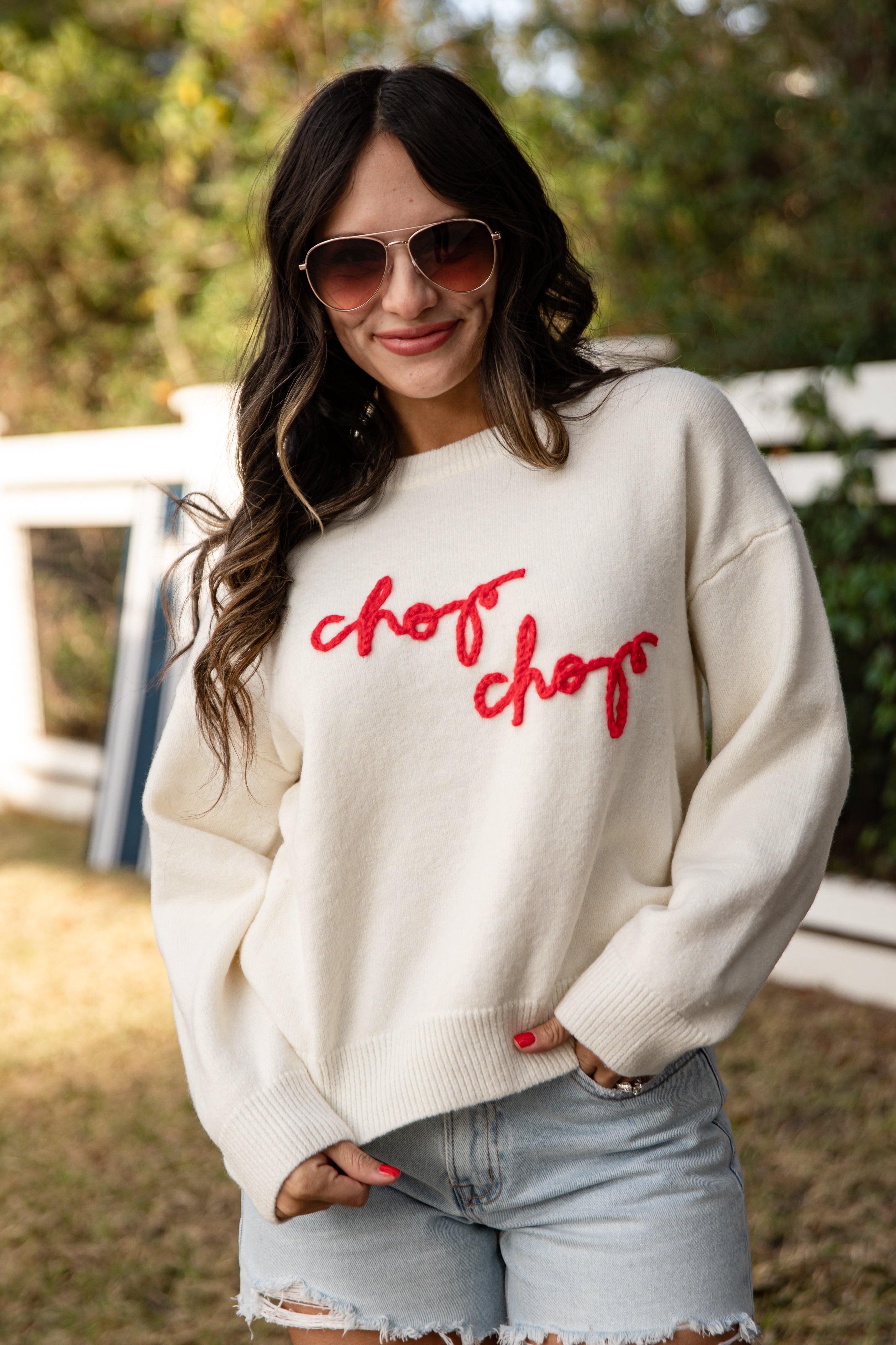 Woman wearing a cream sweater with &