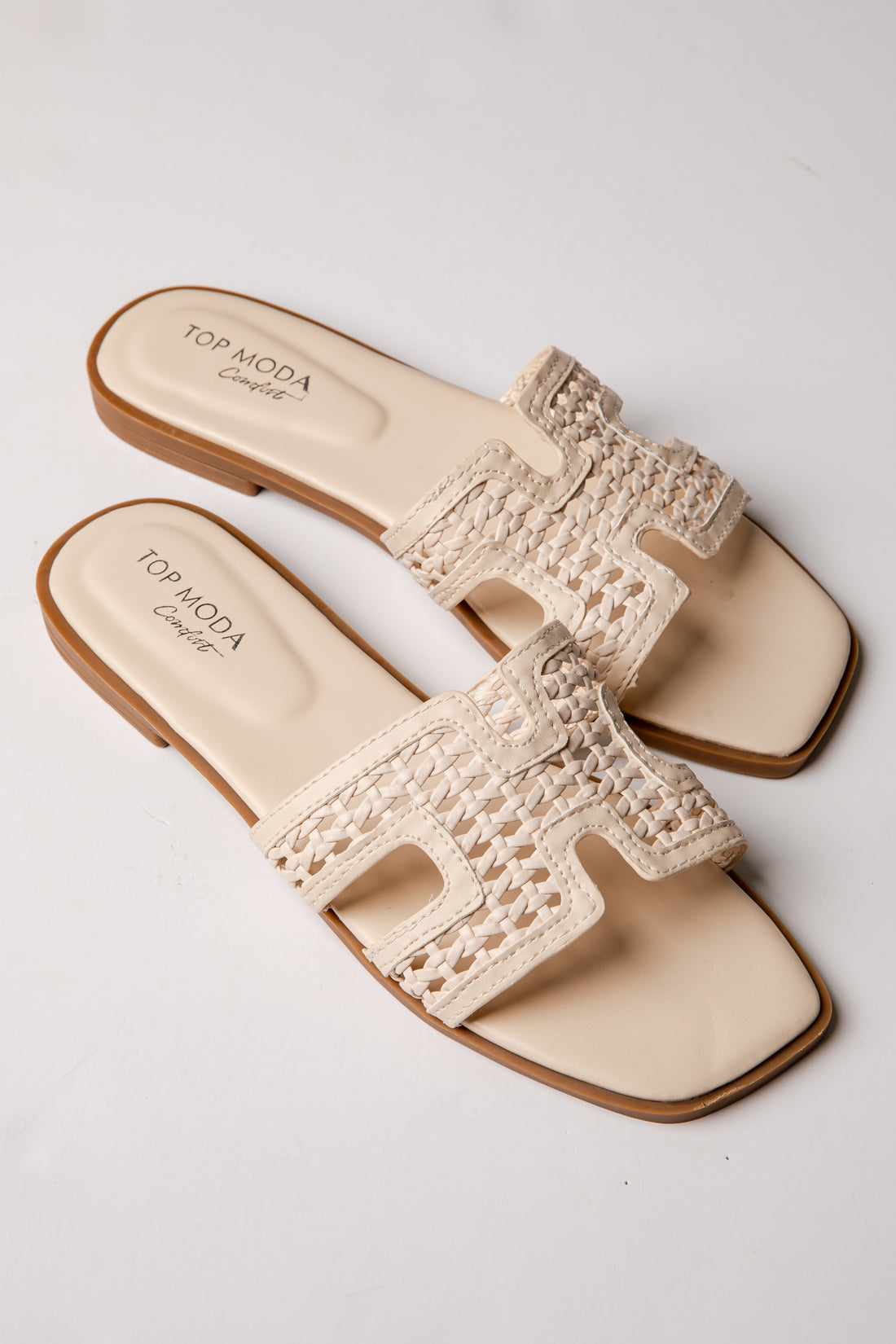 Beige sandals with crochet details on a white background