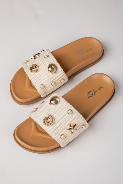 Pair of embellished sandals with a white background