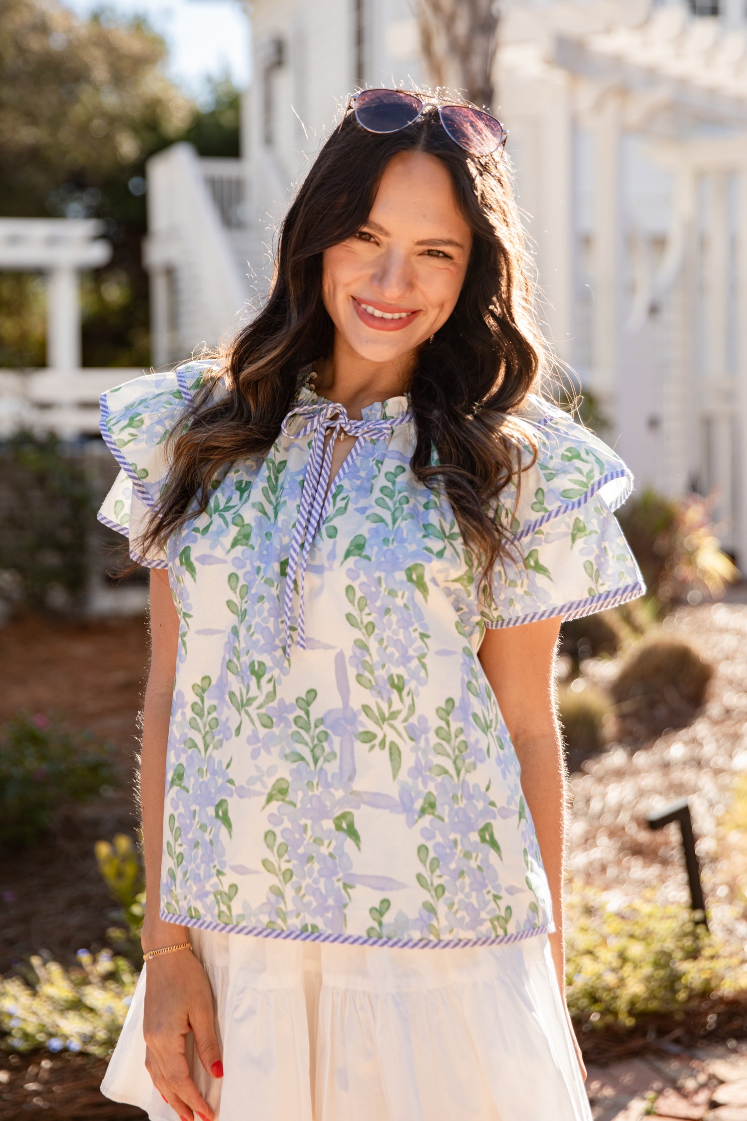 Woman wearing a floral blouse outdoors with a blurred background