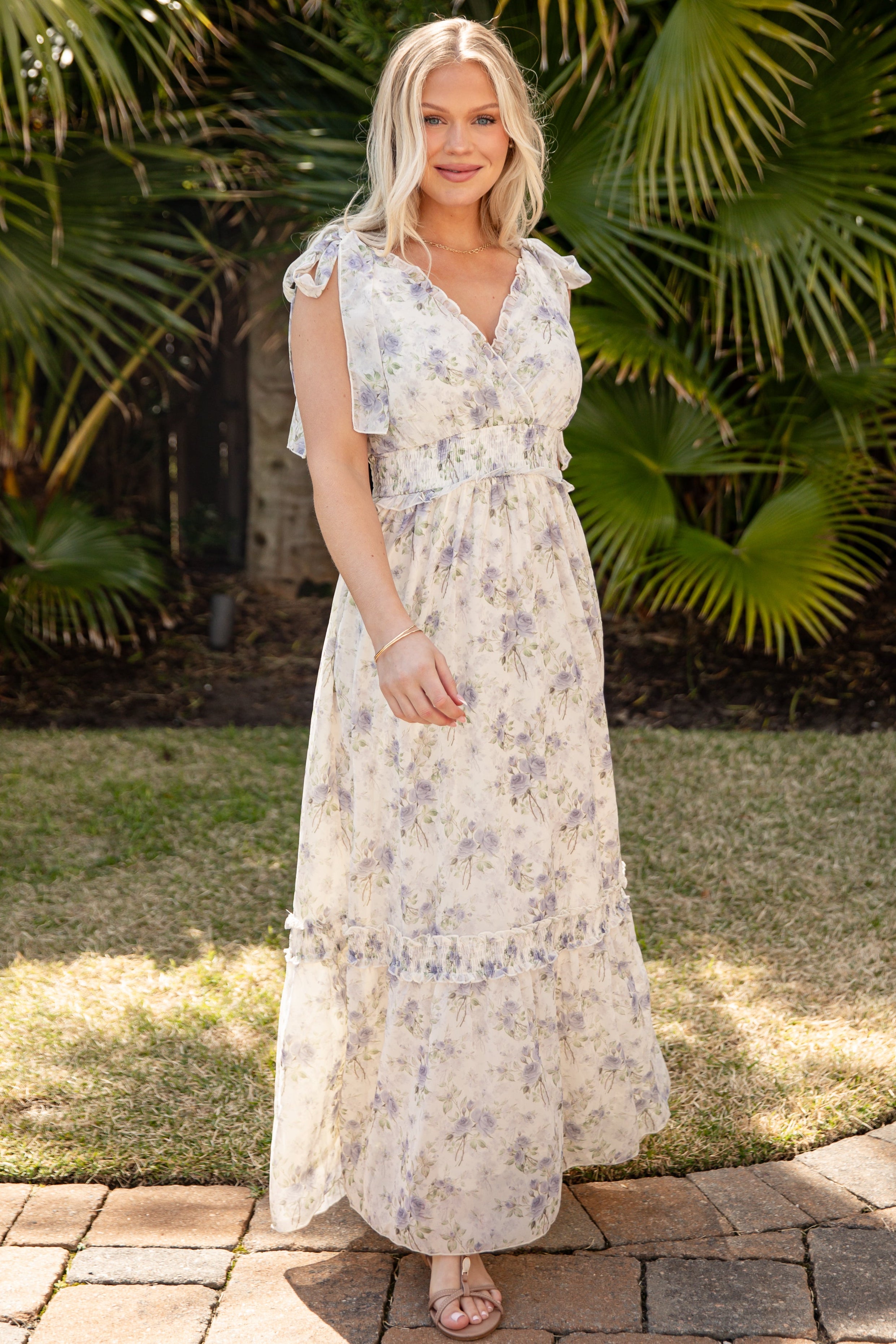 Woman in a floral dress standing in front of tropical plants