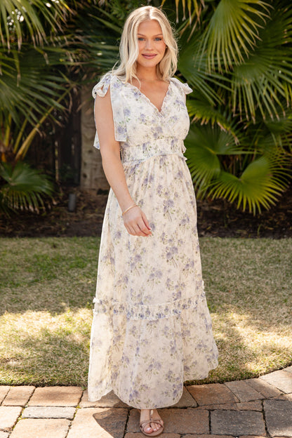 Woman in a floral dress standing in front of tropical plants