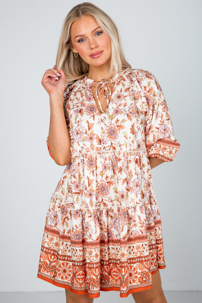 Woman wearing a patterned dress against a plain background