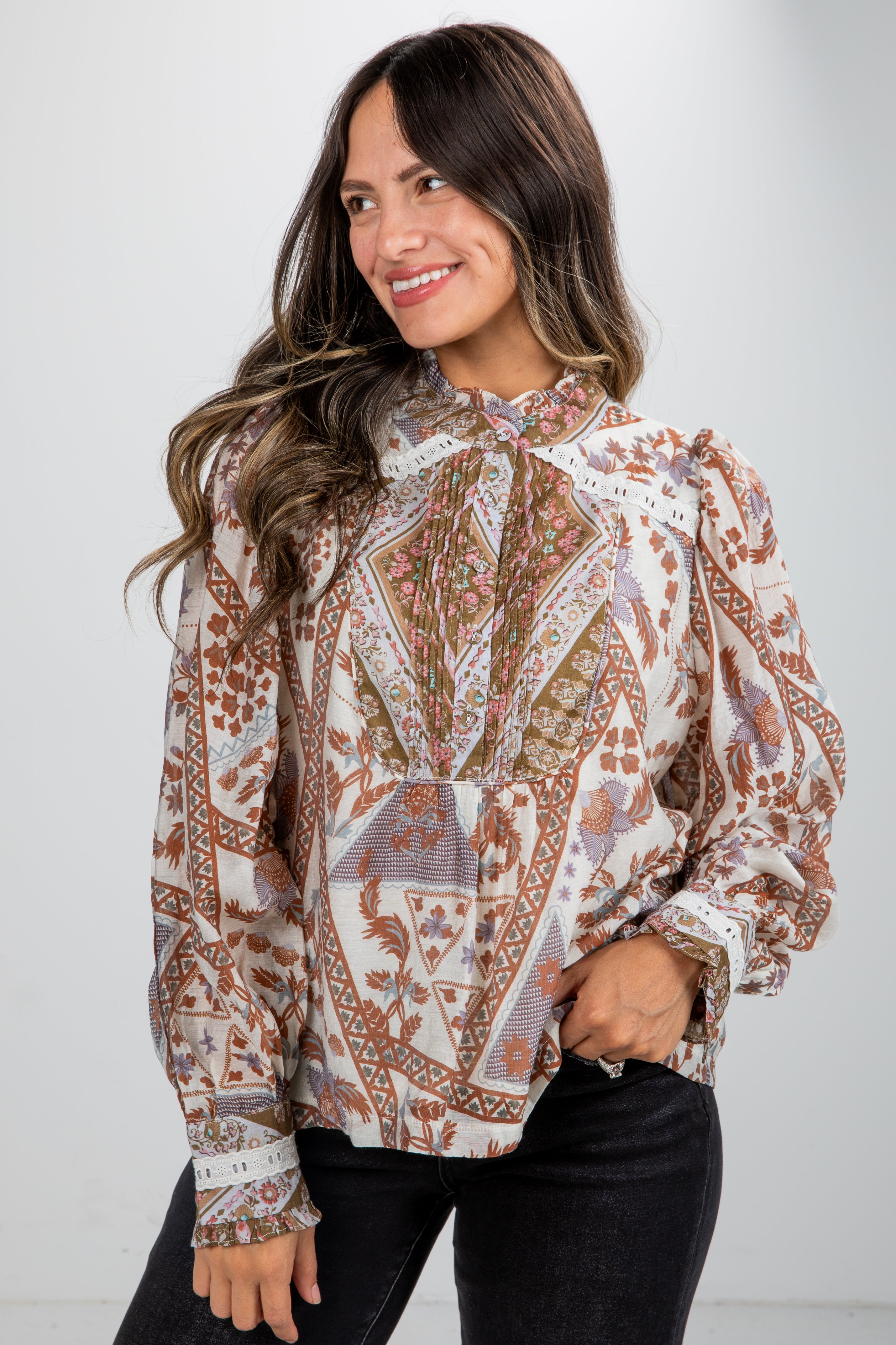 Woman wearing a patterned blouse with a plain background
