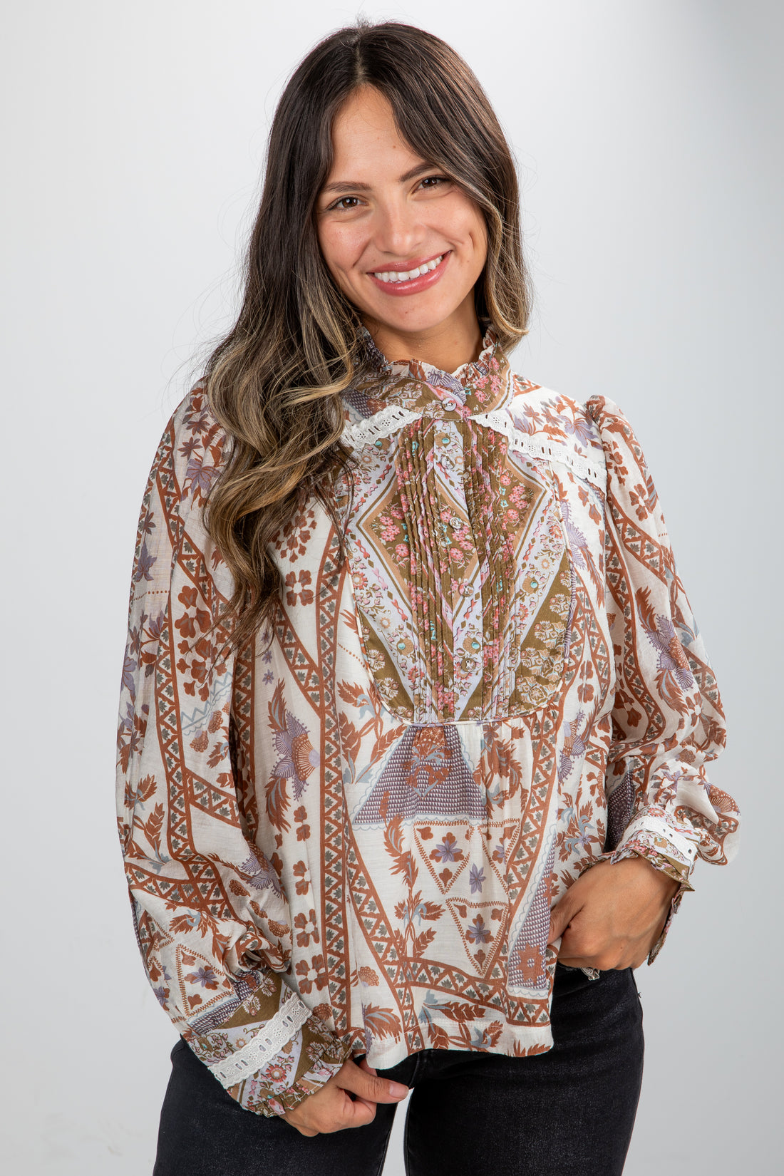 Woman wearing a patterned blouse against a plain background