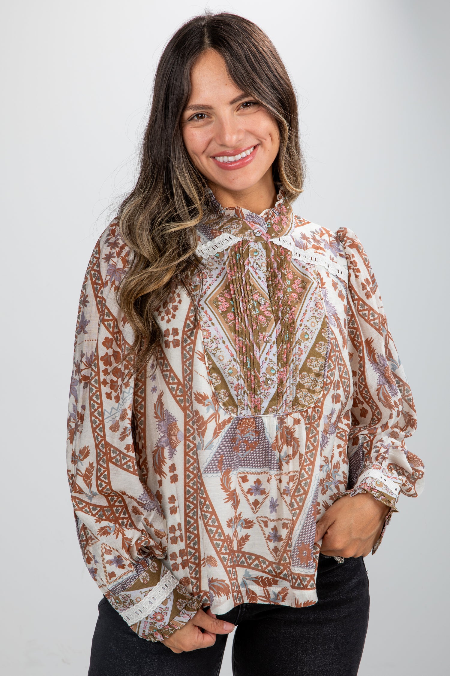 Woman wearing a patterned blouse against a plain background