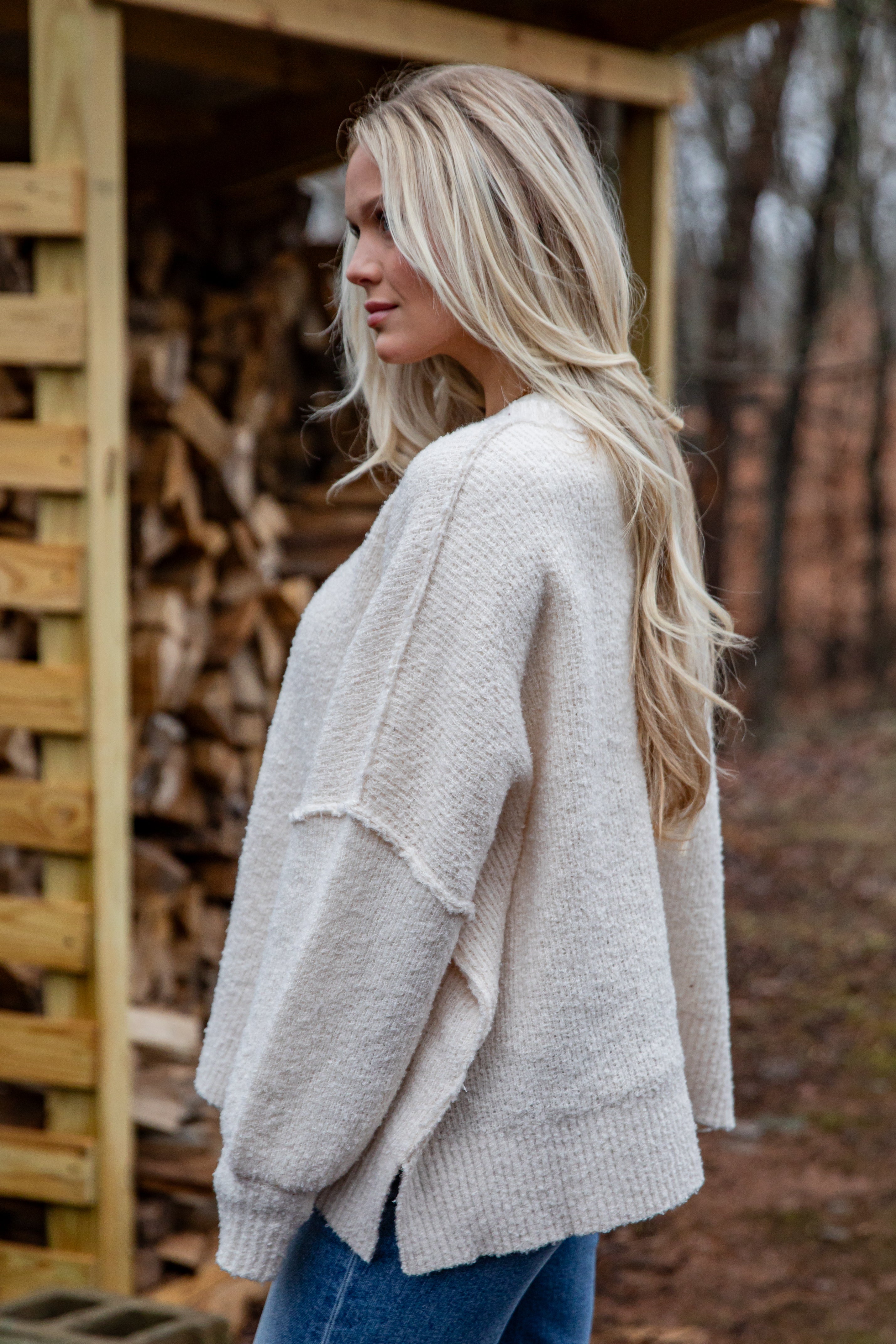 Woman wearing a beige cardigan in a forest setting