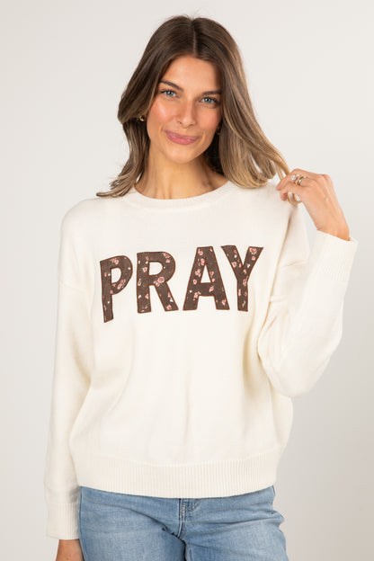 Woman wearing a white sweater with &