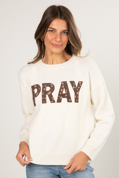 Woman wearing a white sweater with &