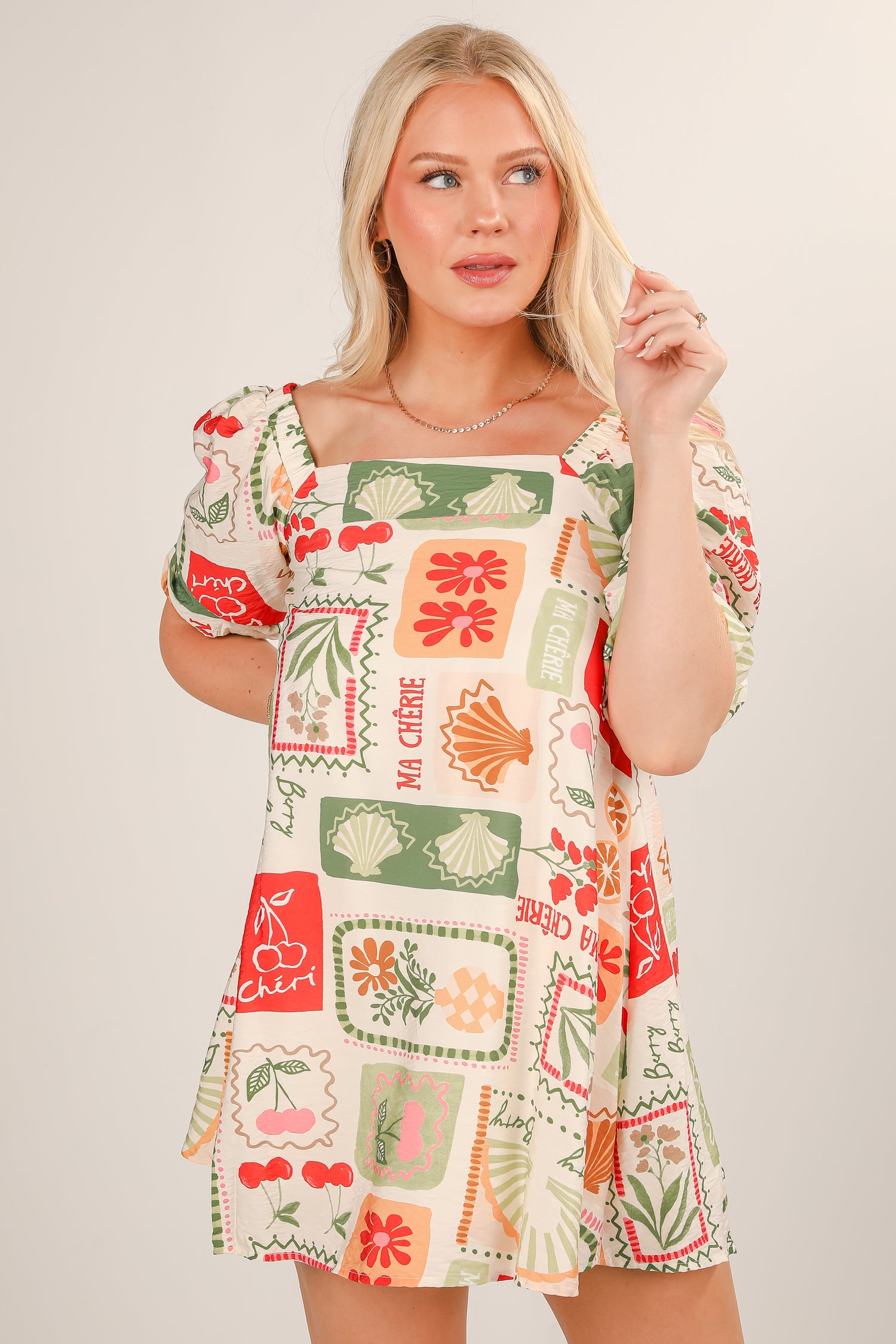 Woman wearing a colorful patterned dress on a plain background