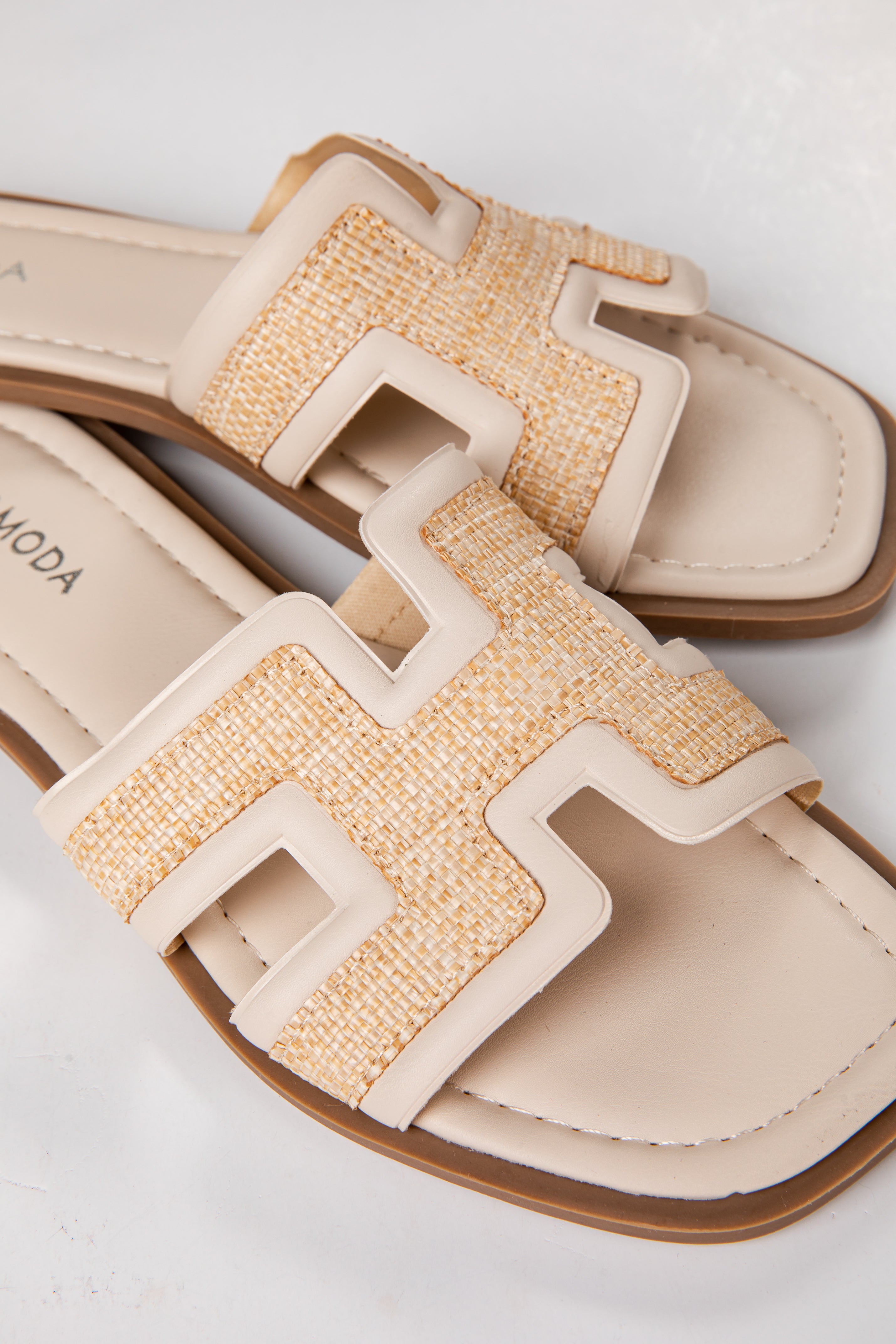 Beige sandals with woven straps on a white background