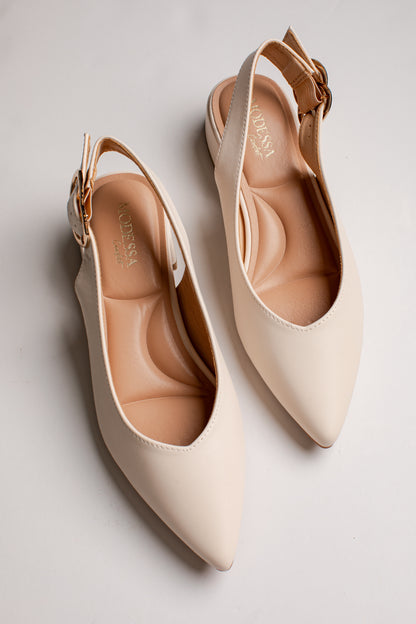 A pair of pointed-toe slingback flats in a light cream color with gold-tone buckle details, displayed on a light gray background.