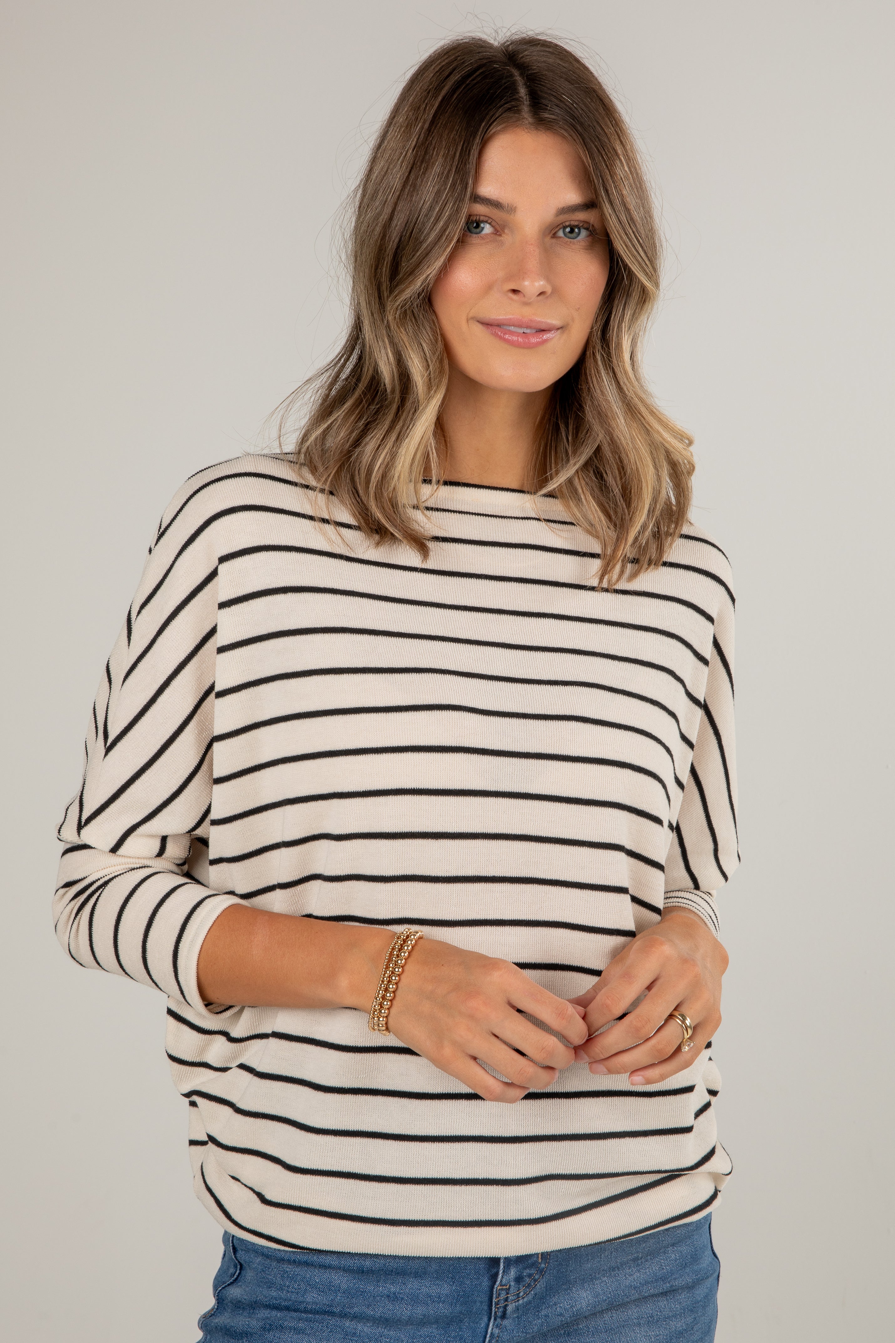 Woman wearing a black and white striped sweater on a plain background