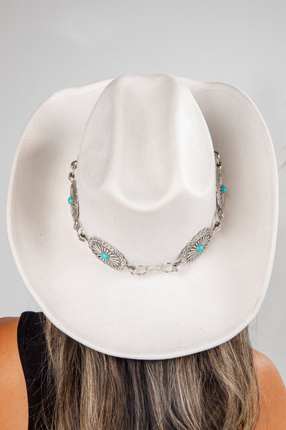 White cowboy hat with a decorative necklace on a plain background