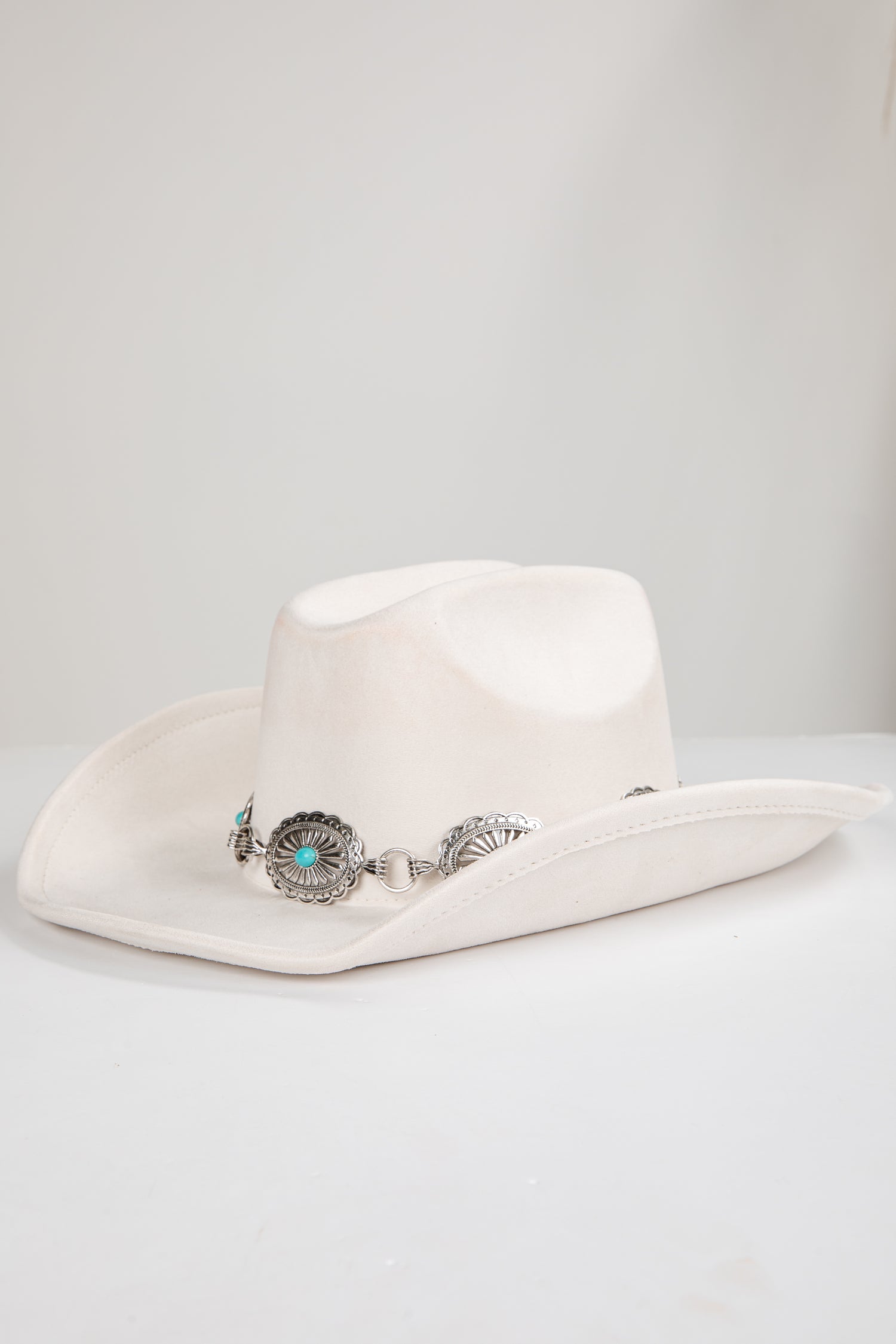 White cowboy hat with decorative band on a white background