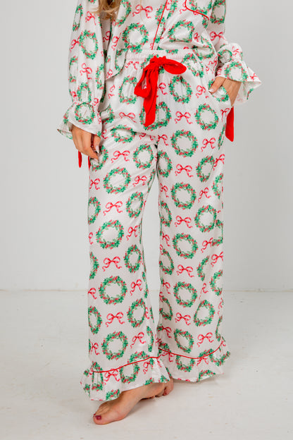 Holiday-themed pajama set with wreaths and bows on a white background