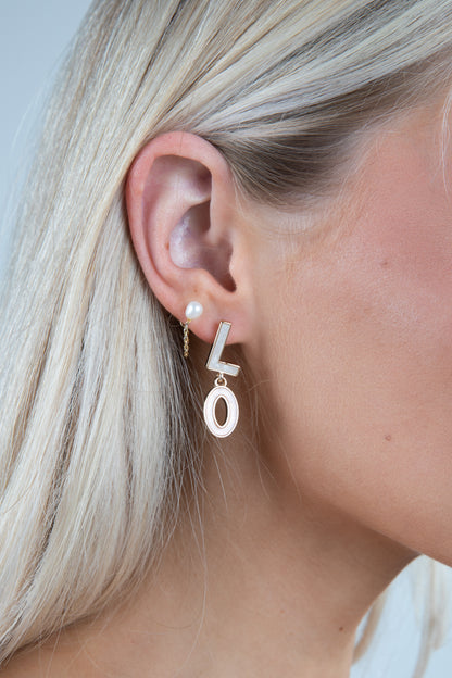 Close-up of a person wearing gold &