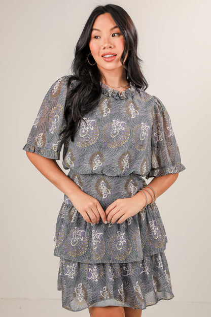 Woman wearing a patterned dress against a plain background