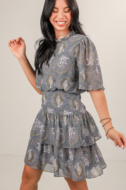 Woman wearing a patterned dress against a plain background