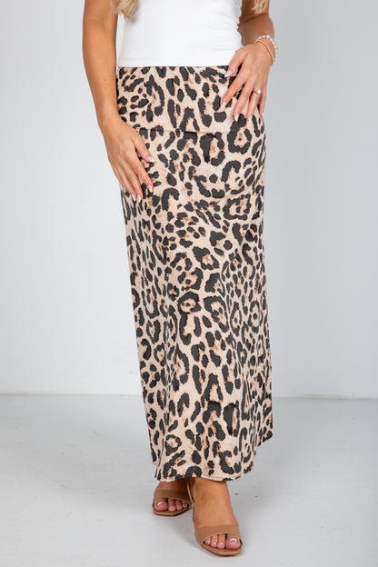 Person wearing a leopard print skirt on a plain background