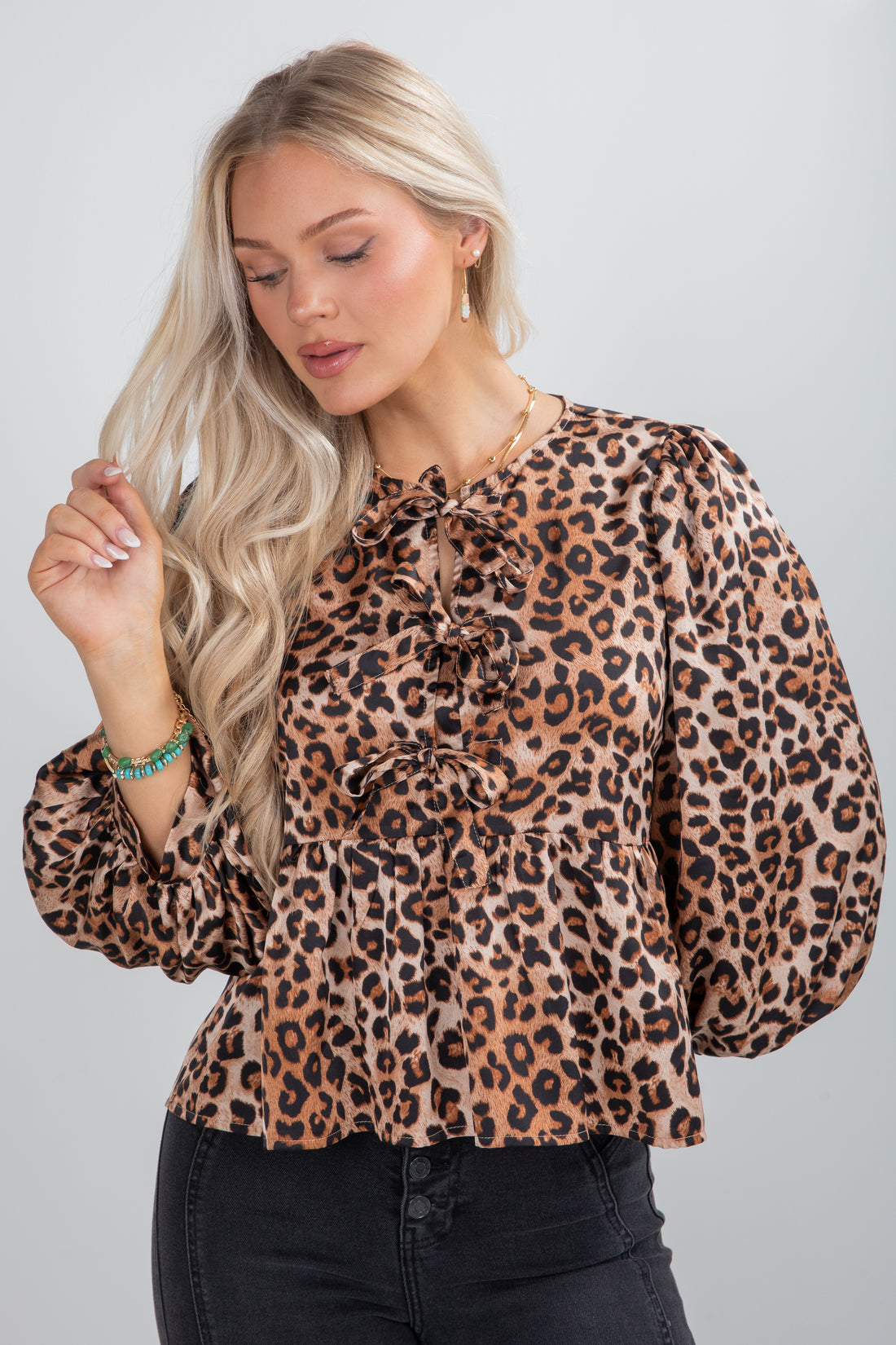 Woman wearing a leopard print blouse against a plain background