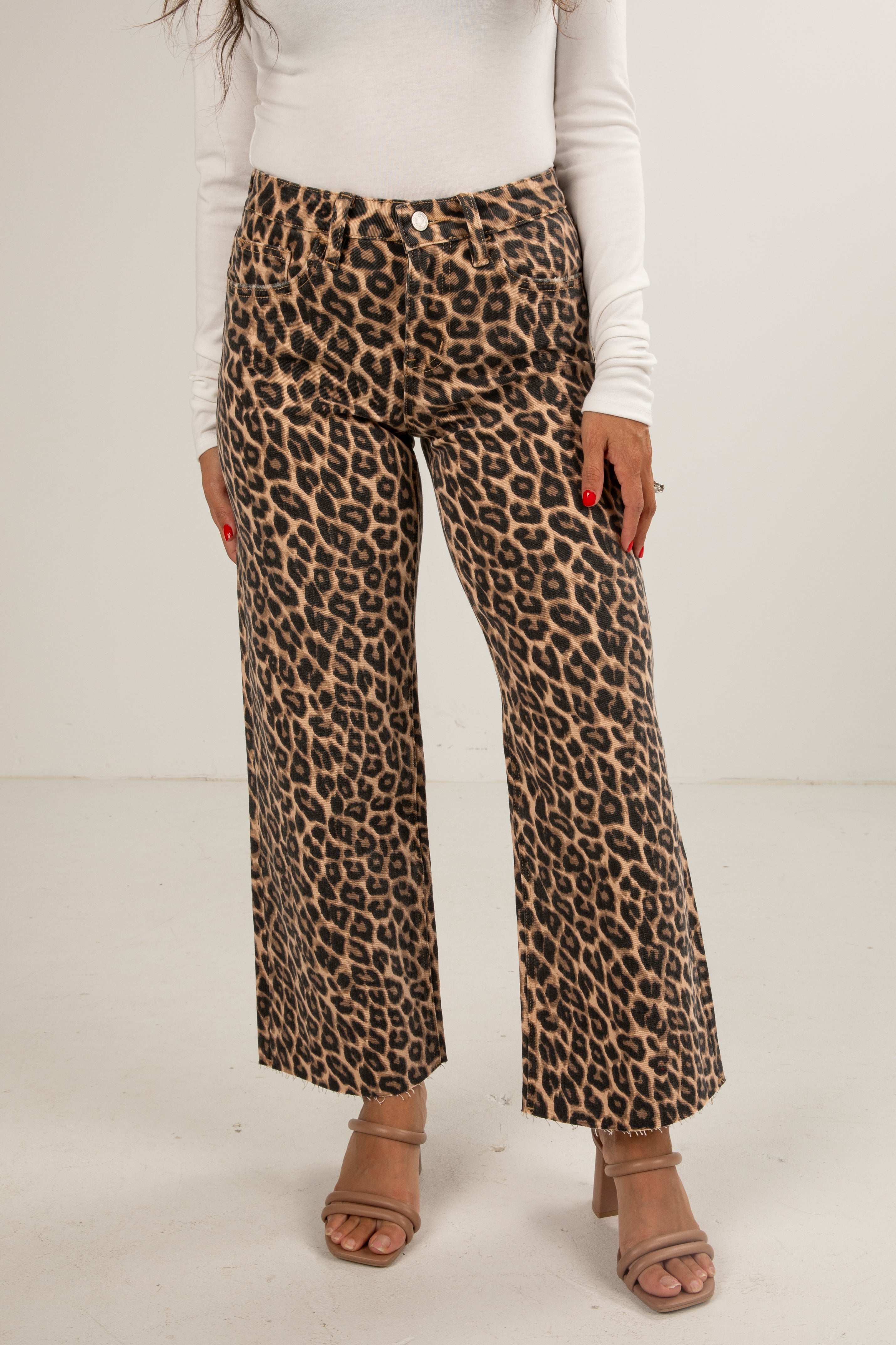 Person wearing leopard print pants on a plain background