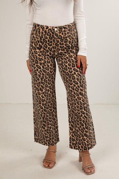 Person wearing leopard print pants on a plain background
