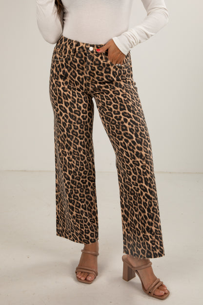 Leopard print pants worn with a white top on a plain background