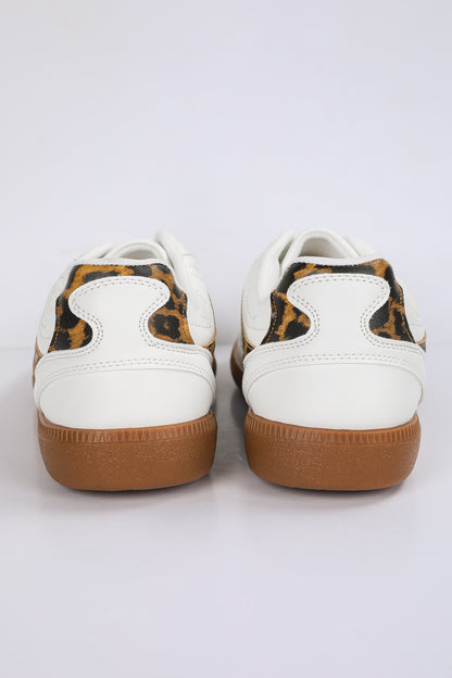 White sneakers with brown soles and leopard print accents on a white background