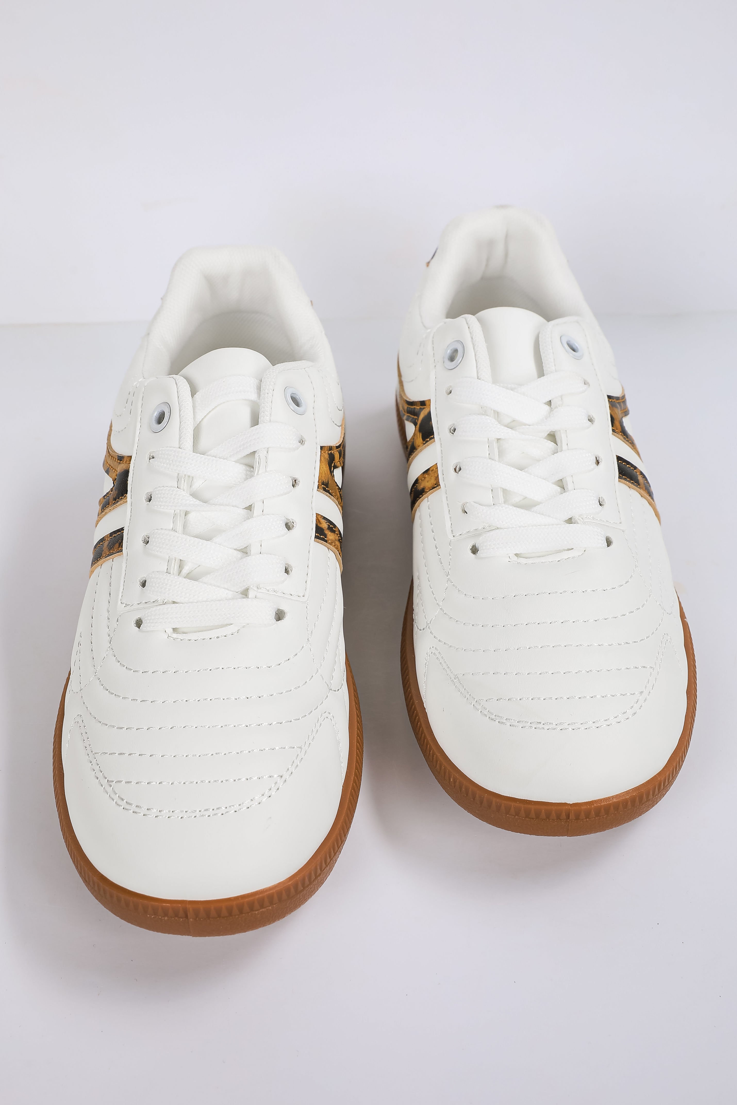 White sneakers with brown soles on a white background
