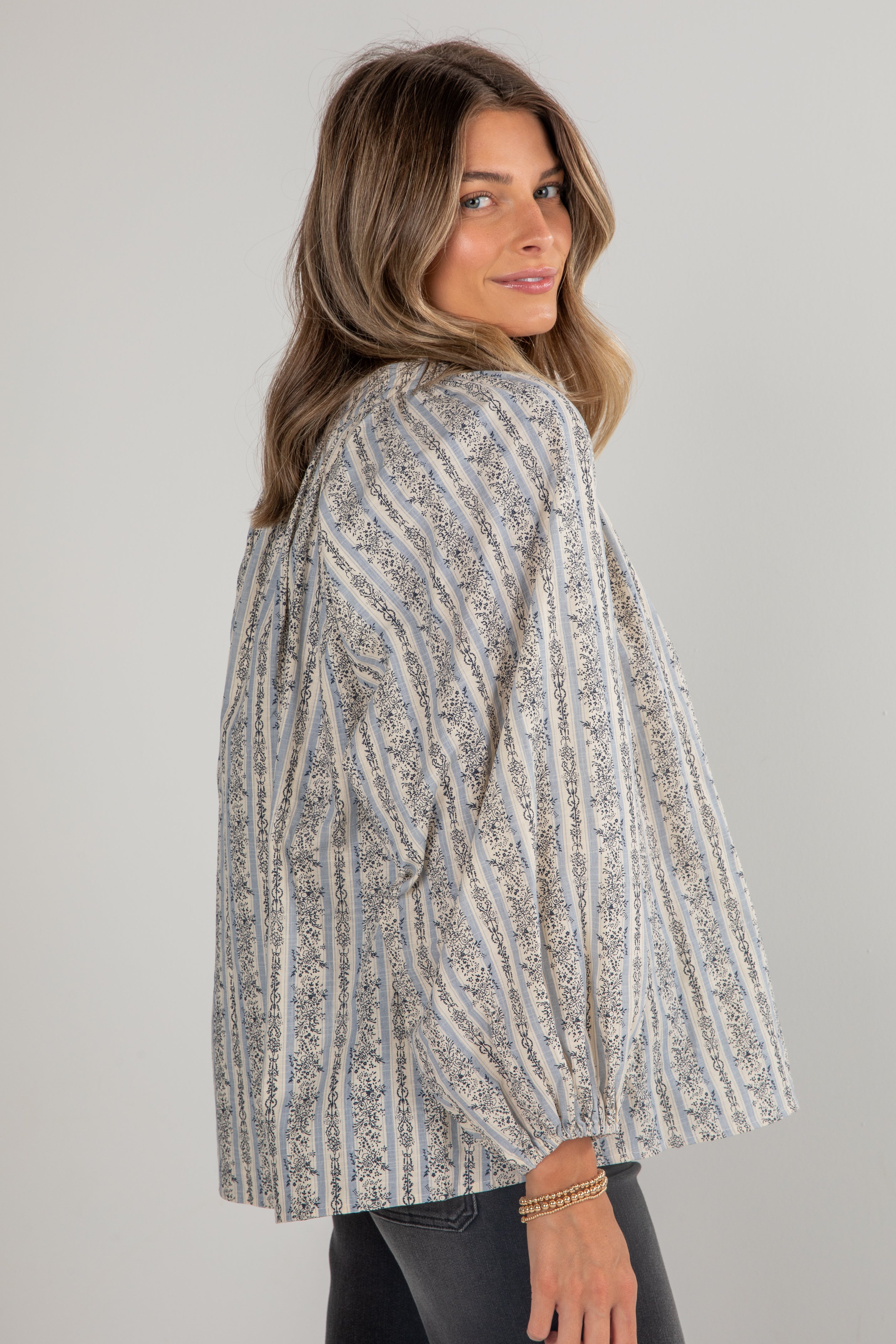 Woman wearing a patterned jacket against a plain background