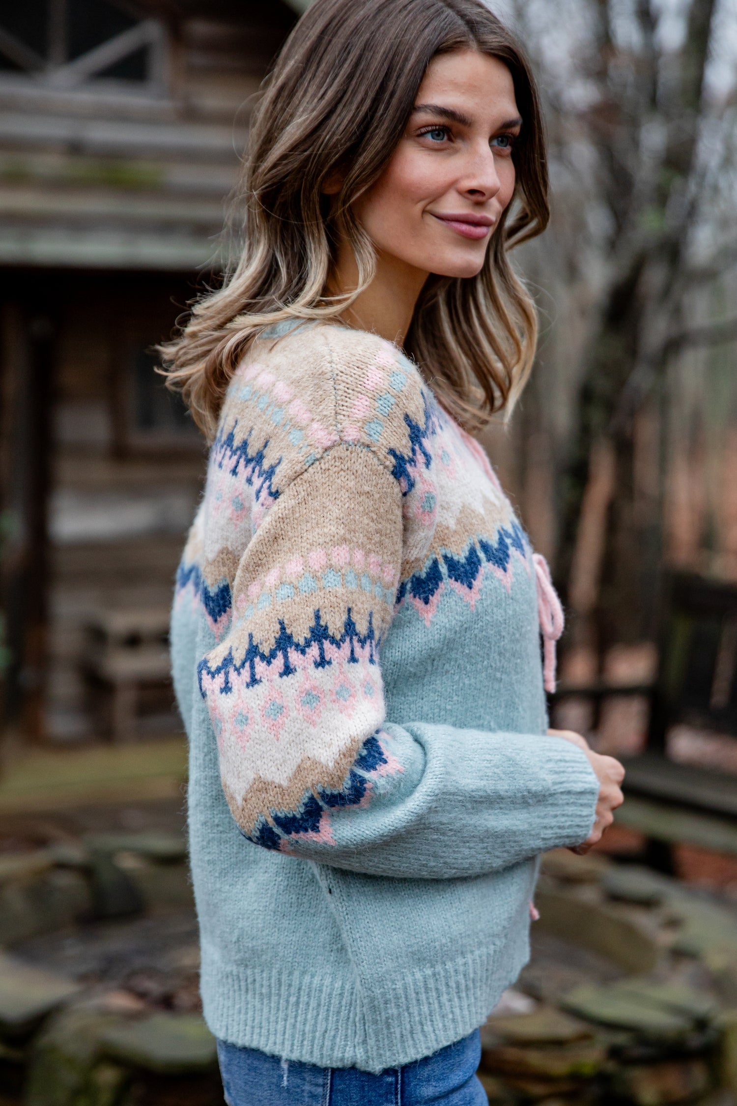 Woman wearing a patterned sweater in an outdoor setting