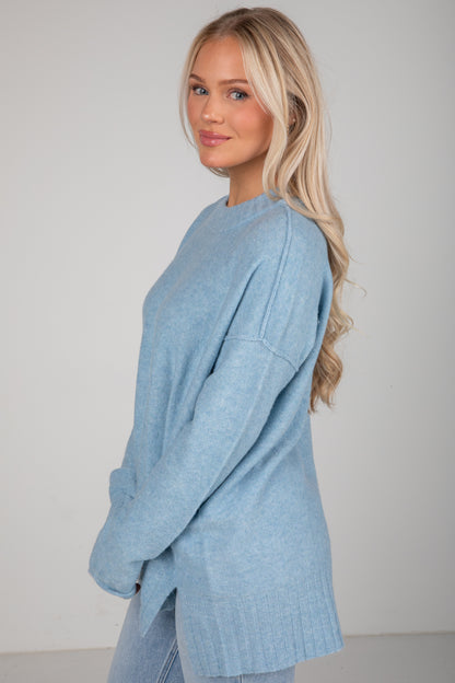 Woman wearing a light blue sweater against a plain background
