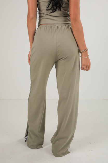 Person wearing beige high-waisted pants on a white background