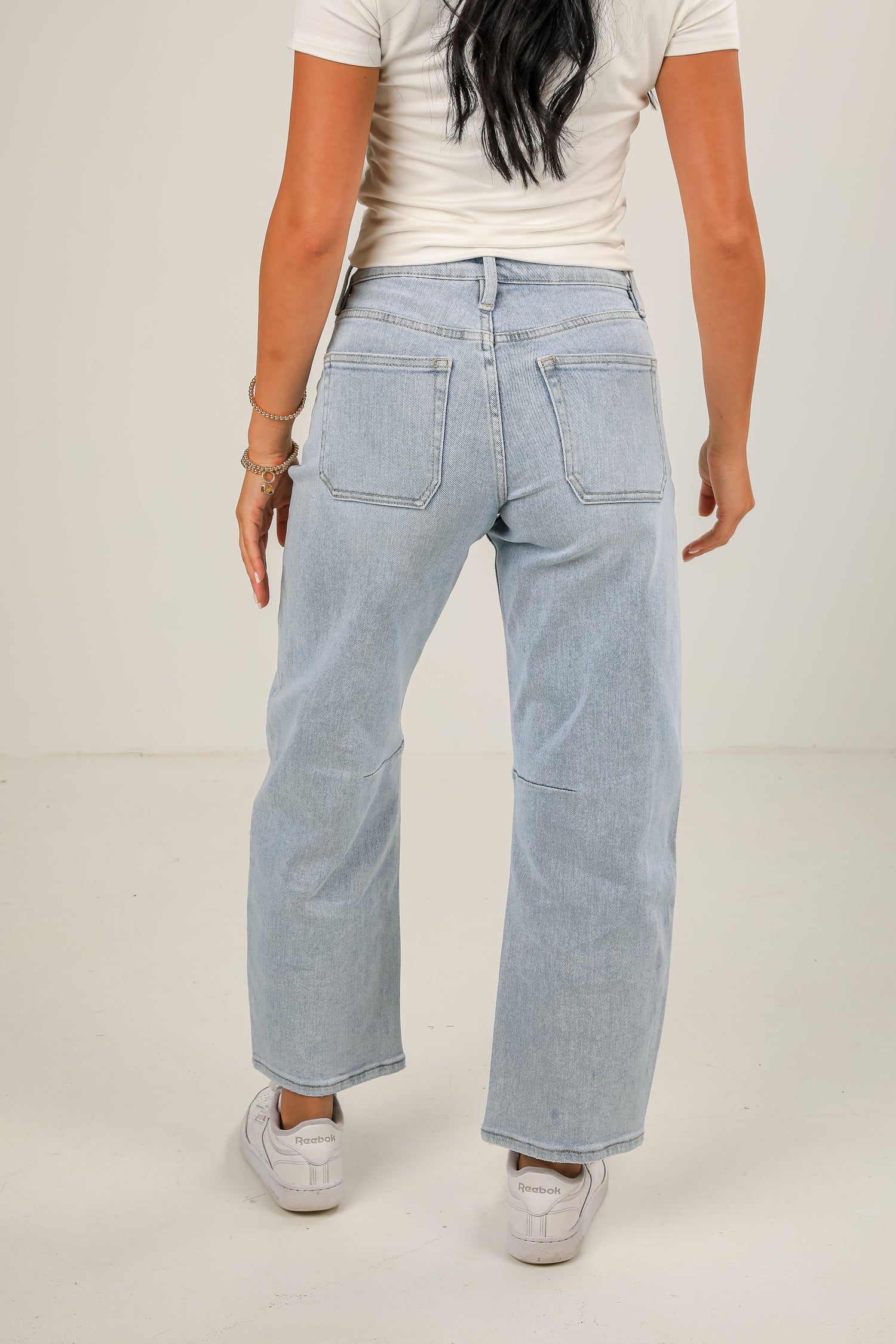 Light blue jeans worn by a person on a plain background