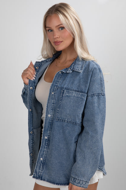 Woman wearing a denim jacket on a plain background