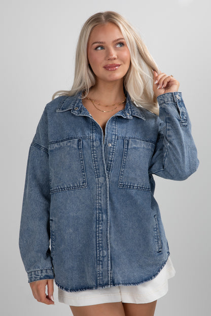 Woman wearing a blue denim jacket on a gray background