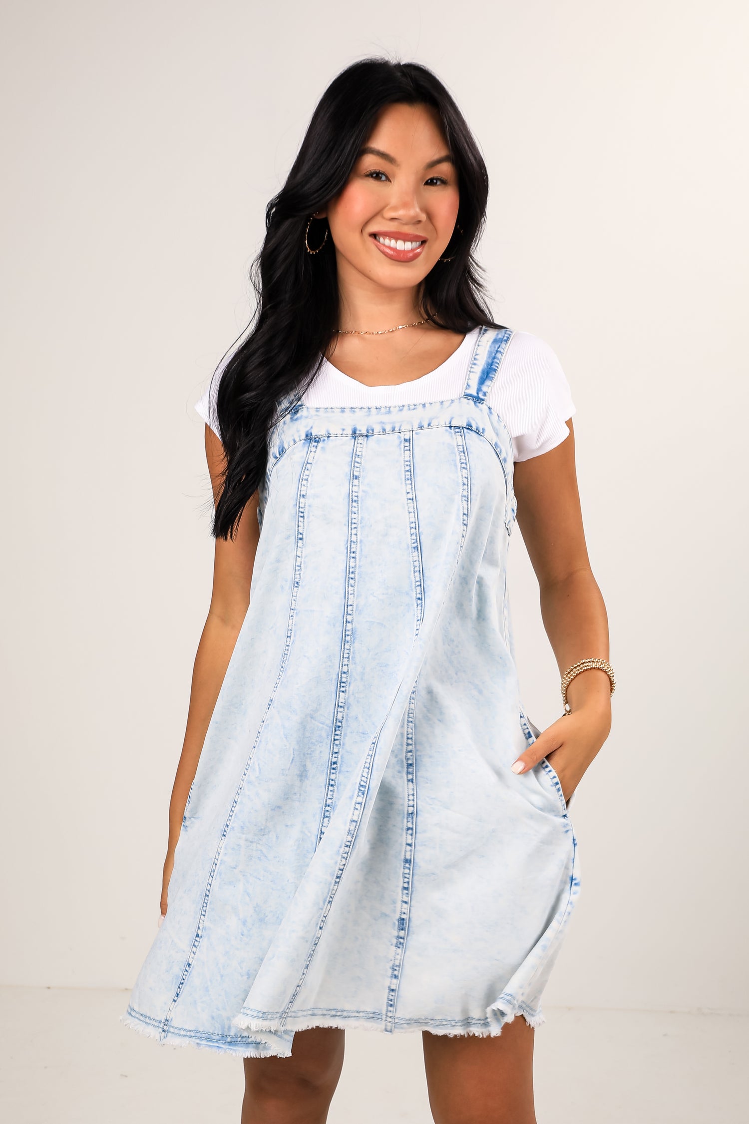Woman wearing a light blue and white dress against a plain background