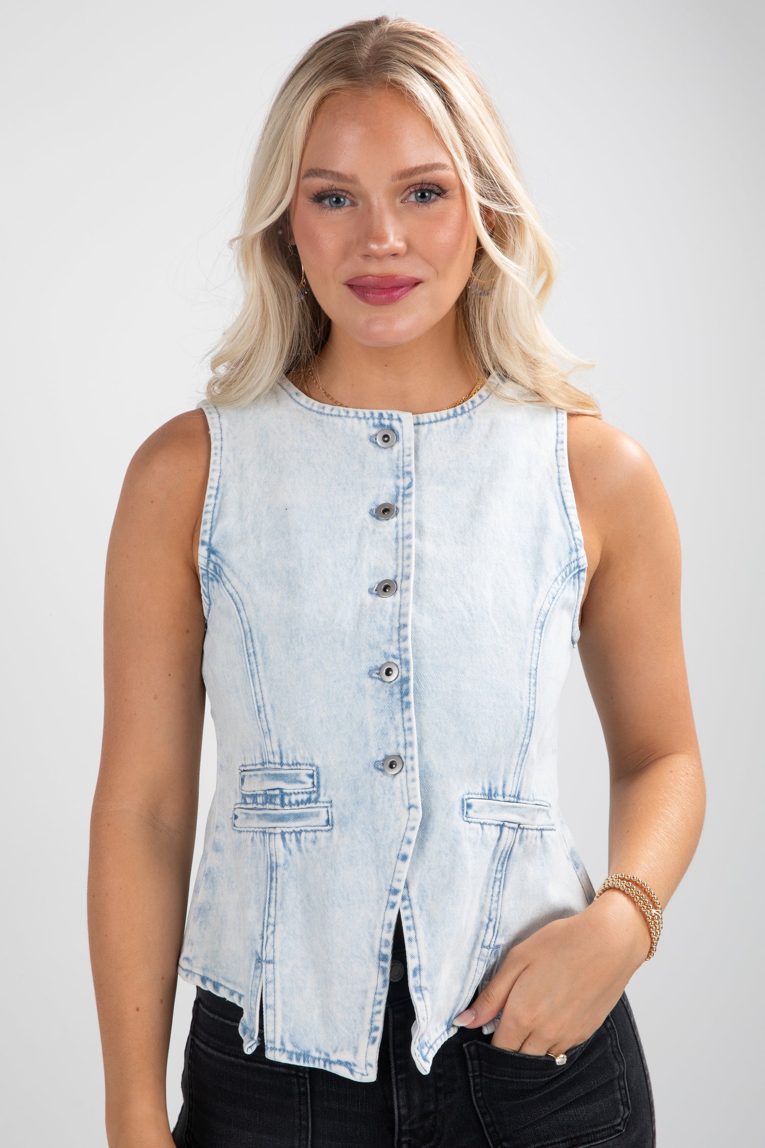 Woman wearing a light blue denim sleeveless shirt on a white background