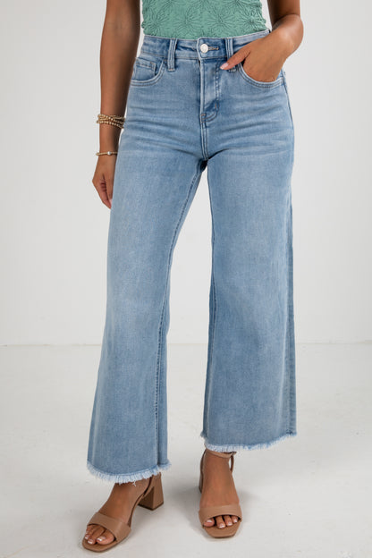 Person wearing light blue jeans on a white background