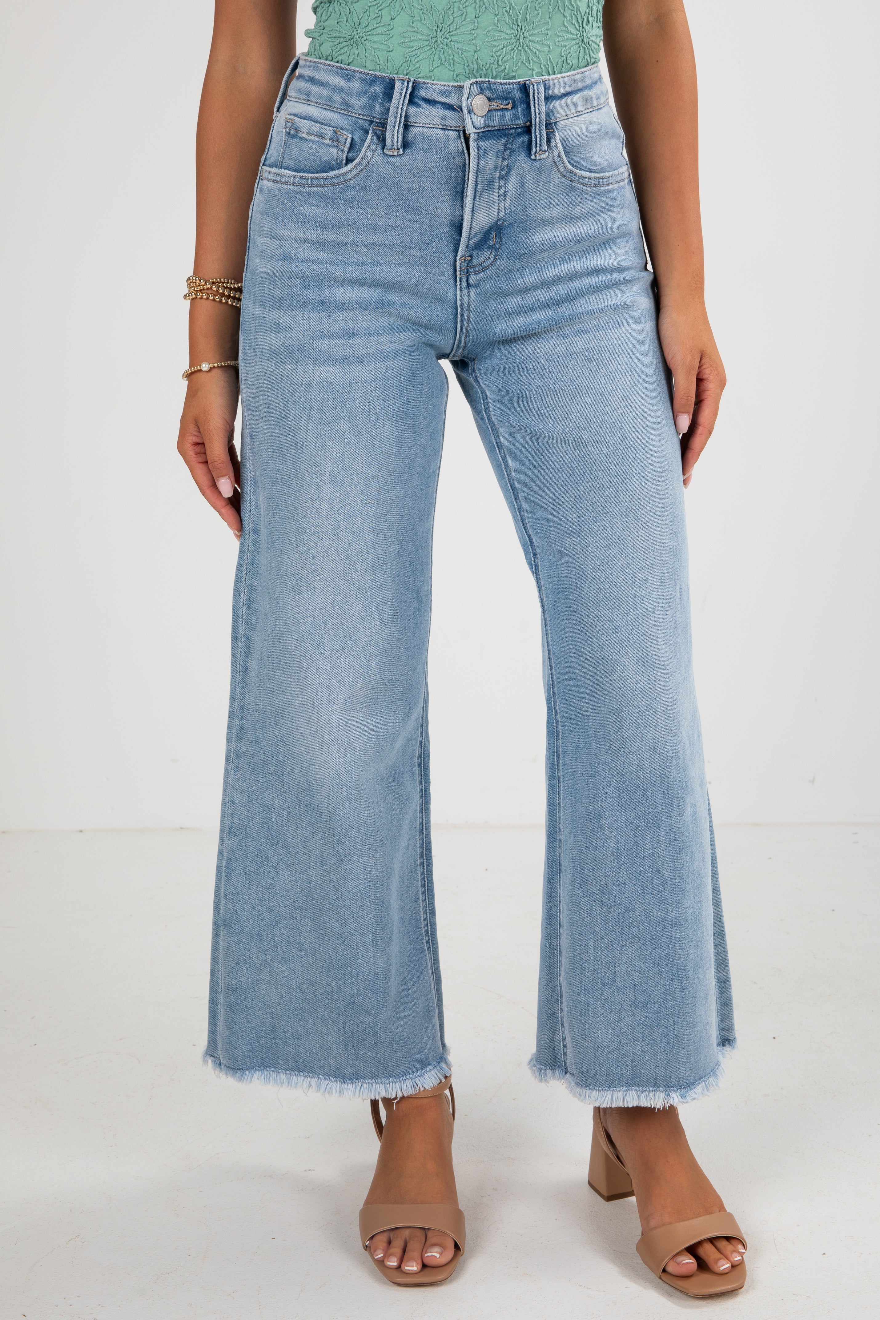 Person wearing light blue wide-leg jeans on a white background