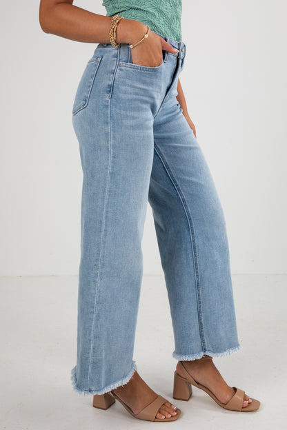 Person wearing light blue jeans on a white background