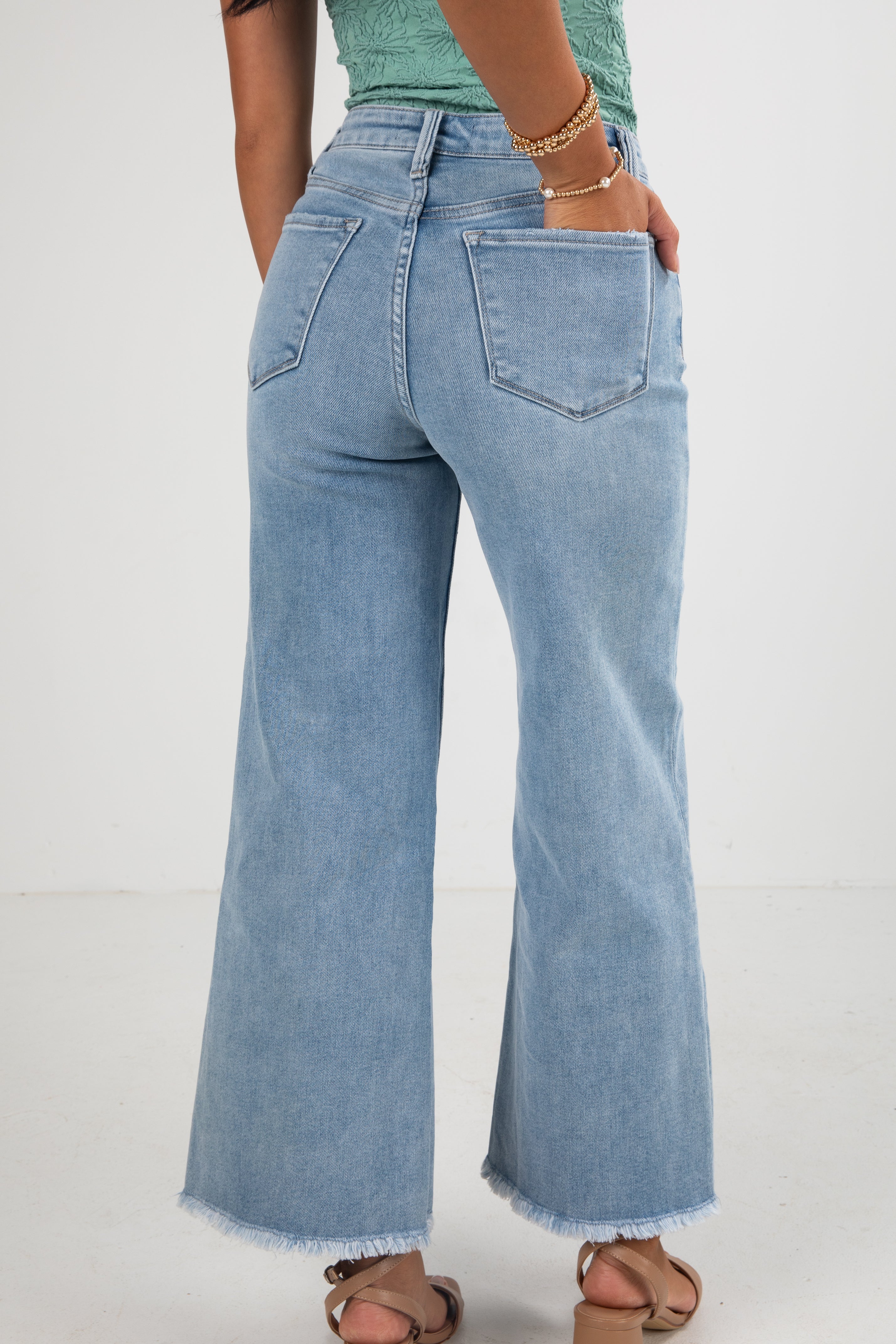 Person wearing light blue jeans on a white background