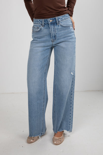 Person wearing light blue jeans on a white background