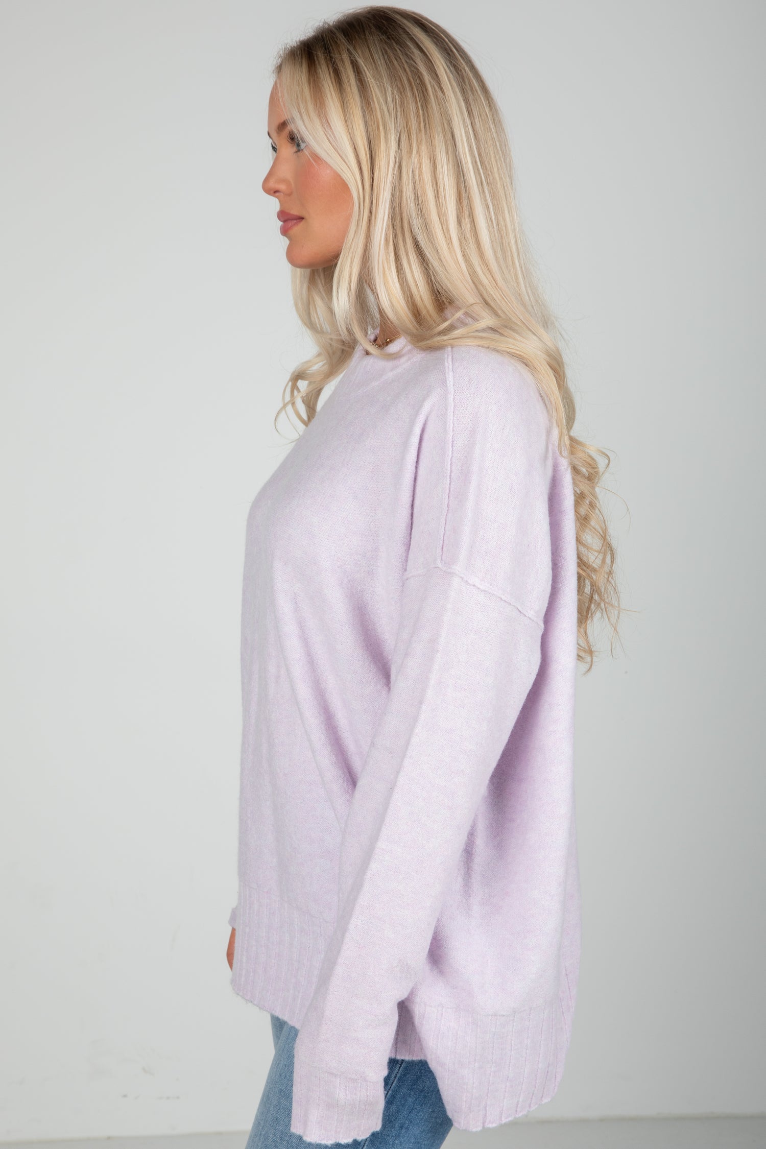 Woman wearing a light purple sweater against a plain background