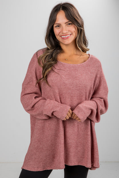 Woman wearing a pink sweater against a white background