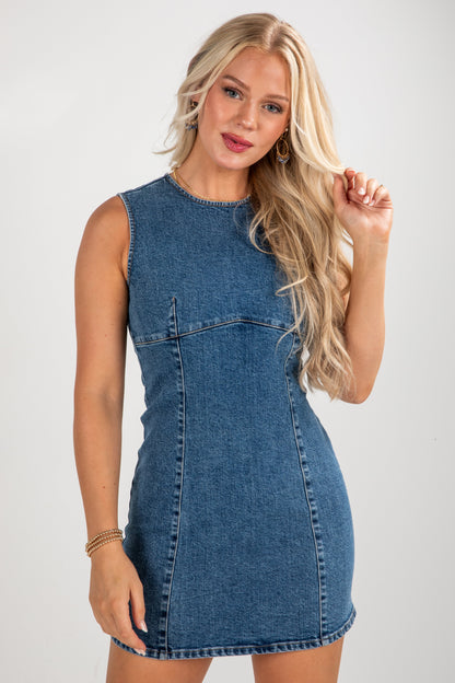 Woman wearing a denim dress against a plain background