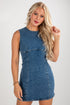 Woman wearing a denim dress against a plain background